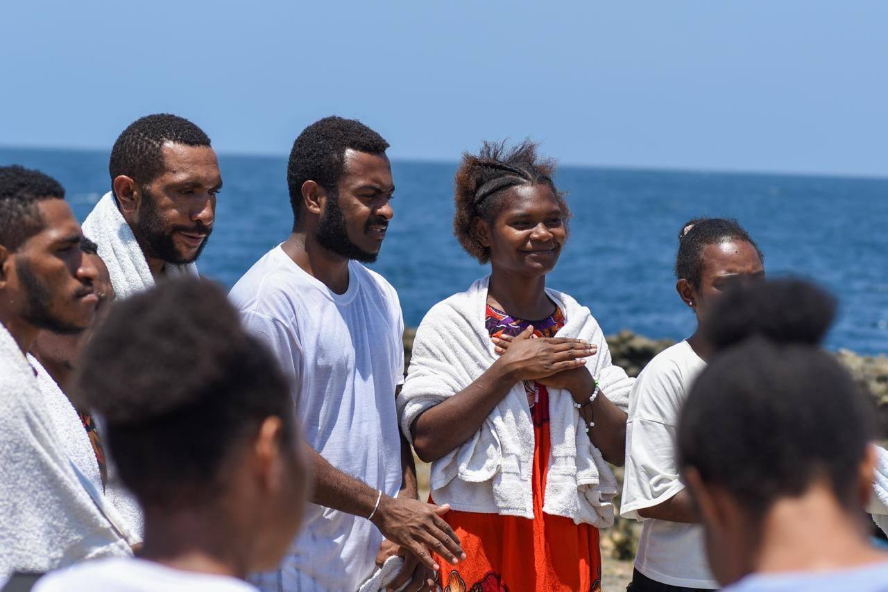 Oral Bible Translation team members gathered beside the sea in Papua New Guinea