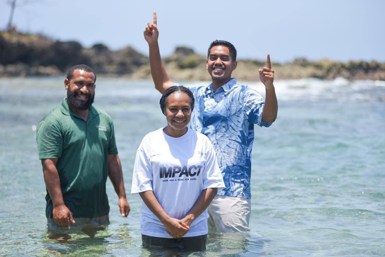 Members of an Oral Bible Translation team standing in the sea in Papua New Guinea
